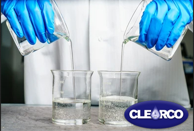 Silcone fluids being poured into flasks by worker with the clearco logo in the foreground
